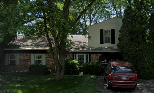 Two-story brick and siding home before roof replacement