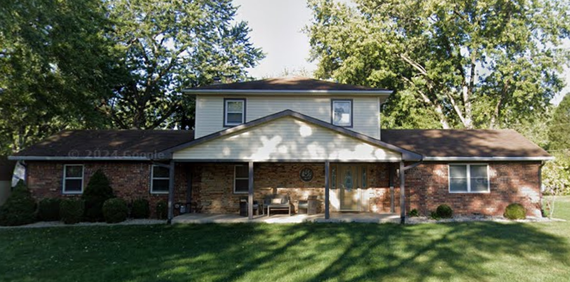 Two-story brick home before roof replacement